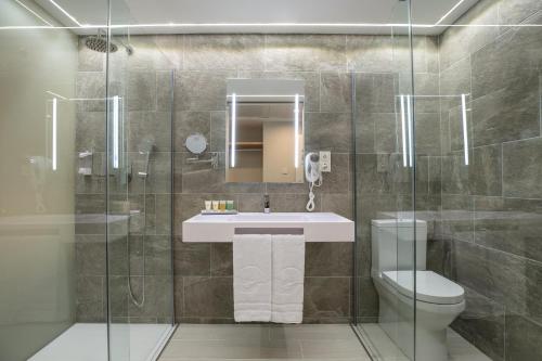 a bathroom with a sink and a toilet and a shower at The Ibiza Twiins - 4* Sup in Playa d'en Bossa