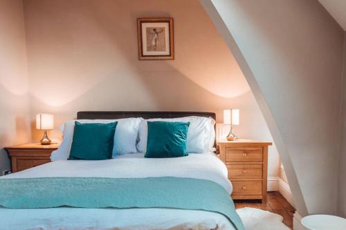 a bedroom with a bed with blue pillows at The Vestry - Sleeps 12 - With Hot Tub in Haworth