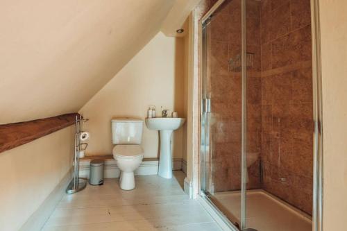 a bathroom with a toilet and a shower at The Vestry - Sleeps 12 - With Hot Tub in Haworth