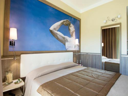 a bedroom with a bed with a painting on the wall at Eracle Hotel in Volla