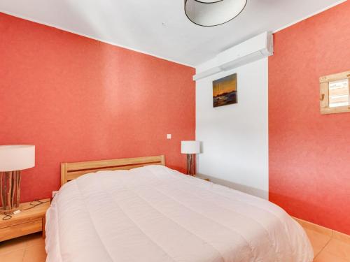 a bedroom with a white bed and red walls at Sunny Roquebrun Getaway in Roquebrun