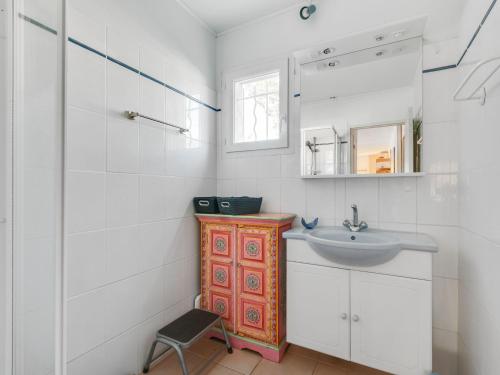 a white bathroom with a sink and a mirror at Sunny Roquebrun Getaway in Roquebrun