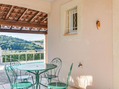 a patio with a table and chairs and a window at Sunny Roquebrun Getaway in Roquebrun