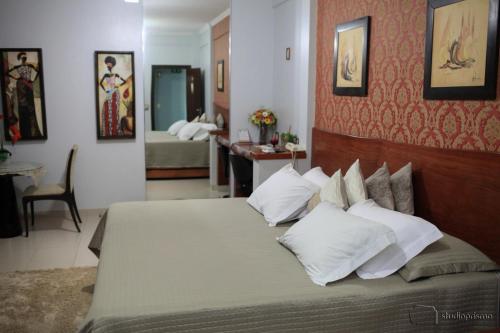 a bedroom with a large bed with white pillows at Hotel Zen in São Gabriel do Oeste