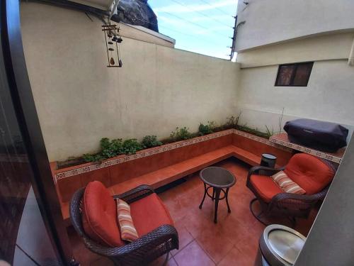 a balcony with two chairs and a table and a bench at Casa Cacho in Tijuana