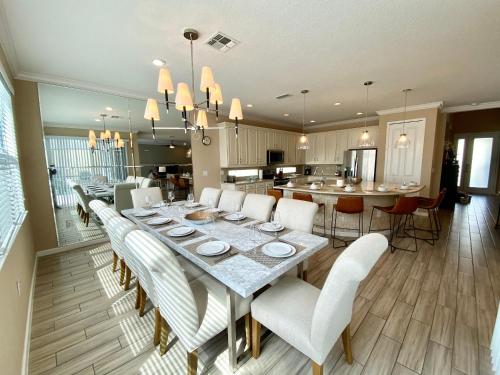 a dining room and kitchen with a long table and chairs at 3830 Premier Villa 6Bd Private Pool and Game Room in Kissimmee