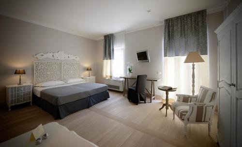 a hotel room with a bed and a desk and chair at Locanda In Borgo Garnì & Wellness in Borgo