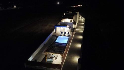 an overhead view of a house with a swimming pool at night at Dorieus Villa in Lachania