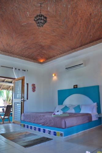 a bedroom with a bed with a wooden ceiling at Nacional Beach Club & Bungalows in Mahahual