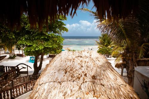 a view of a beach with a straw roof at Nacional Beach Club & Bungalows in Mahahual