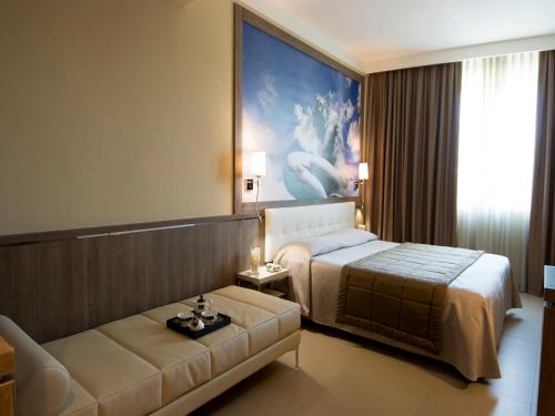 a hotel room with a bed and a couch at Eracle Hotel in Volla