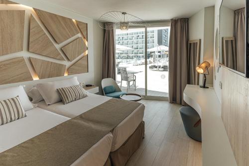 a hotel room with a bed and a balcony at The Ibiza Twiins - 4* Sup in Playa d'en Bossa