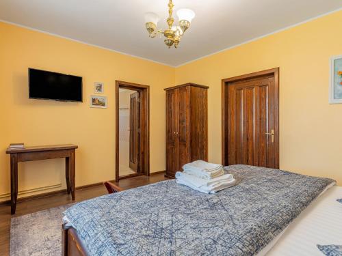 a bedroom with a bed and a tv on the wall at Casa Saraste in Râşnov