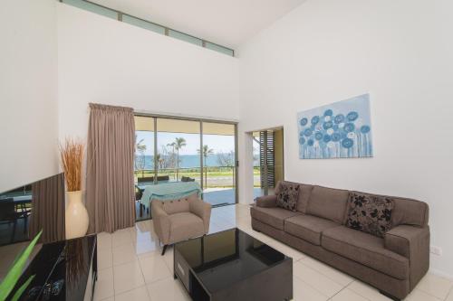 a living room with a couch and a table at Beaches on Lammermoor Apartments in Yeppoon