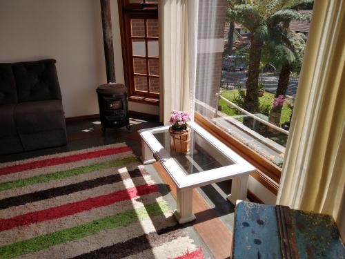 a living room with a table and a window at El Refugio 700 in Gramado