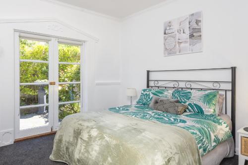 Un dormitorio blanco con una cama grande y una ventana en Croft Cottage en Hepburn Springs