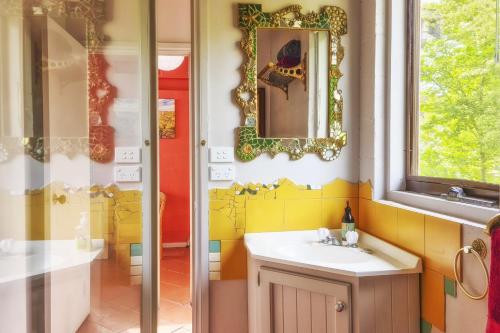 y baño con lavabo y espejo. en Croft Cottage en Hepburn Springs