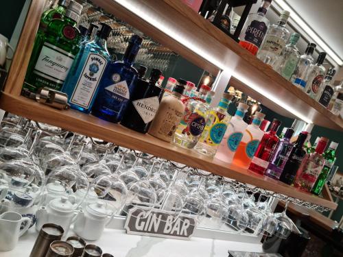 a bar with many different types of alcohol bottles and glasses at The Red Lion in Kilsby