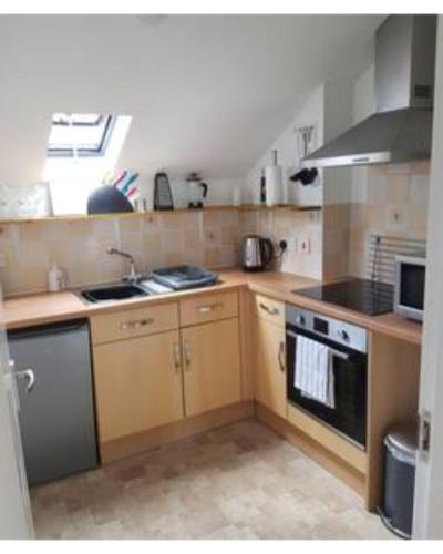 uma pequena cozinha com um fogão e um lavatório em The Maltings - Apartments 1 em Shepton Mallet