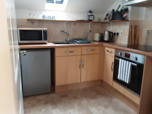 a small kitchen with a sink and a microwave at The Maltings - Apartments 1 in Shepton Mallet