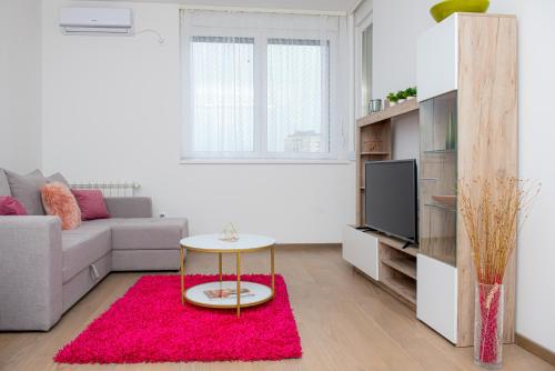 a living room with a couch and a red rug at LUST PREMIUM Apartments in Kragujevac