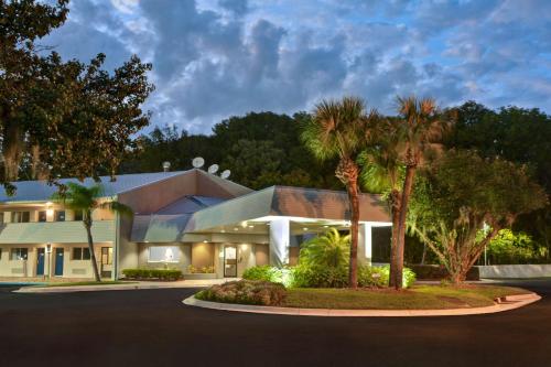 a house with palm trees in front of it at Studio 6-Jacksonville, FL - Baymeadows in Jacksonville