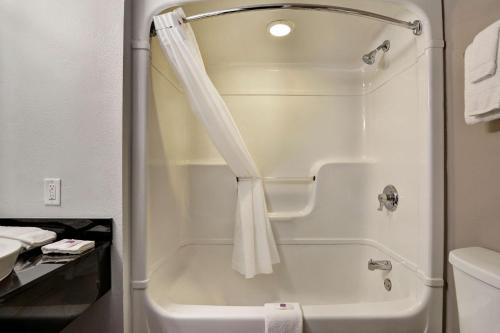 a bathroom with a shower with a shower curtain at Studio 6-Jacksonville, FL - Baymeadows in Jacksonville