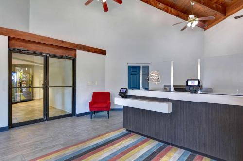 a bar with a red chair in a room at Studio 6-Jacksonville, FL - Baymeadows in Jacksonville