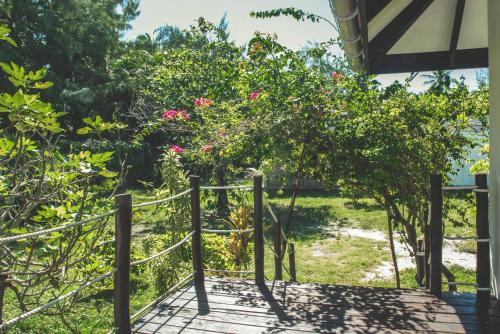 a gate to a garden with pink flowers at Le Coconut Lodge in Avatoru