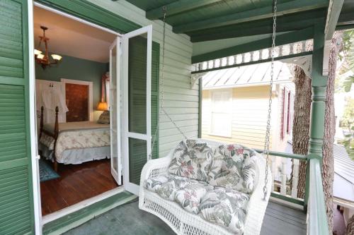a porch with a swinging chair and a bedroom at Historic Sevilla House (Adults only) in Saint Augustine