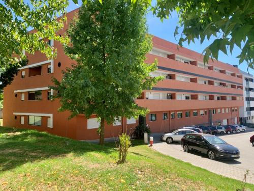 a large building with cars parked in a parking lot at The University of Minho-Campus Gualtar Apartment 1 in Braga