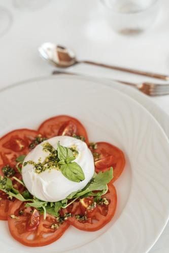 a plate of food with an egg on top of tomatoes at The Ibiza Twiins - 4* Sup in Playa d'en Bossa