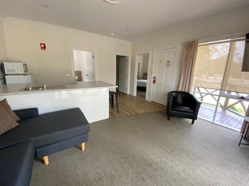 a living room with a couch and a kitchen at Campaspe Lodge in Echuca