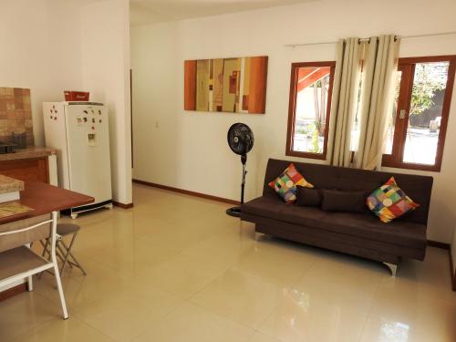 een woonkamer met een bank en een koelkast bij Lovely Pipa in Pipa