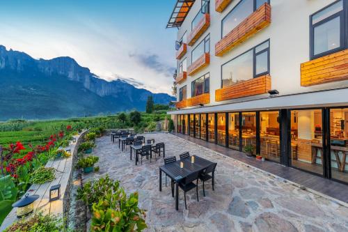a patio with tables and chairs in front of a building at Enshi Grand Canyon Yutan Muyun Guesthouse in Enshi