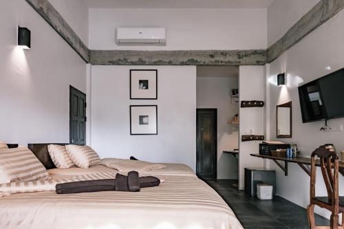 a bedroom with a bed and a flat screen tv at Palin Family Cottage in Chiang Rai