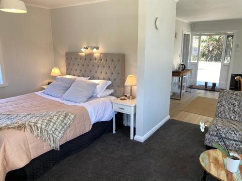 une chambre avec un grand lit et un salon dans l'établissement Ohariu Farm Cottage, à Johnsonville