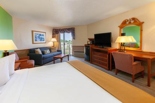 a hotel room with a bed and a desk and a television at Apple Tree Inn; SureStay Collection by Best Western in Petoskey