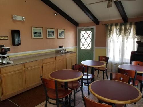 una habitación con 2 mesas y sillas y un bar en Americas Best Value Inn Arkansas City, en Arkansas City