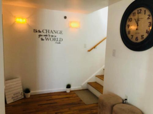 a room with a clock on the wall and stairs at UPDATED Amazing Bi -Level Condo minutes from water views of New York City in North Bergen