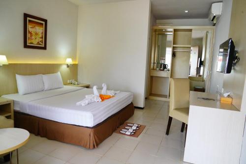 a hotel room with a bed and a kitchen at Hotel Metropole in Batu