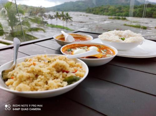 a table topped with plates of food on a table at The Anchorage Athirapilly Resort in Athirappally
