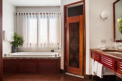 a bathroom with a bath tub and a sink at Amanjaya Pancam Suites Hotel in Phnom Penh