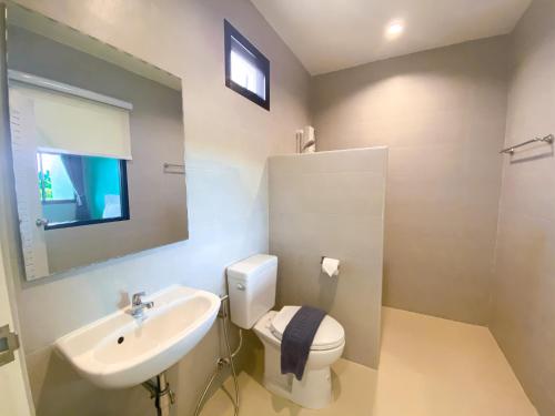 a bathroom with a sink and a toilet and a mirror at Rock Resort in Ratchaburi