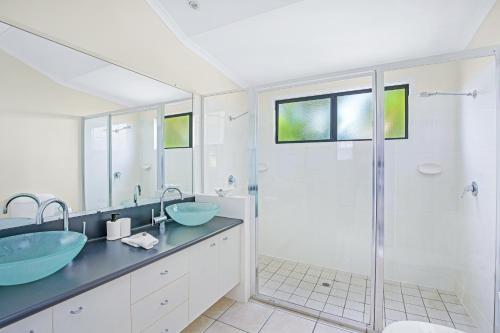 a bathroom with two sinks and a shower at Tin Can Bay Marina Villas in Tin Can Bay