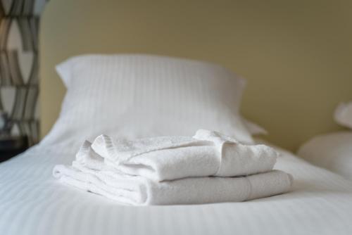 a stack of white towels sitting on a bed at Zenith Hotel Caen in Caen