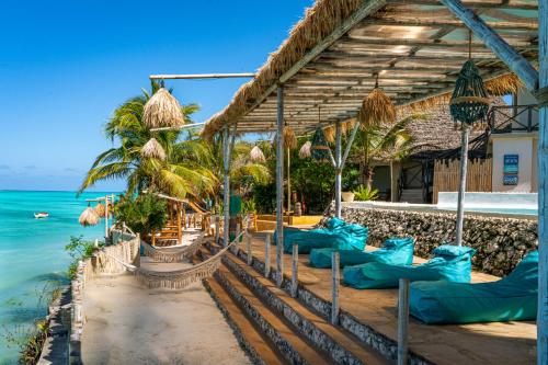 a resort with blue pillows on the beach at Coral Rocks Hotel & Restaurant in Jambiani