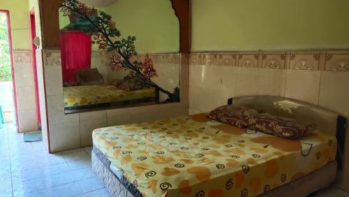 ein Schlafzimmer mit einem Bett in einem Zimmer mit einem Spiegel in der Unterkunft Hotel Sayna in Sibolangit