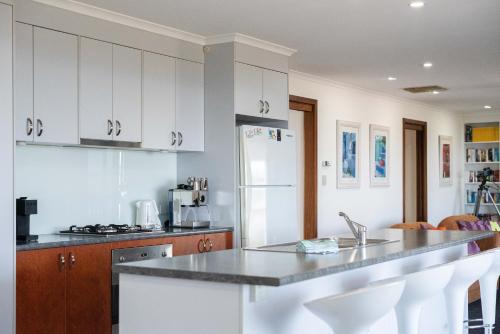a kitchen with white cabinets and a counter top at Beach House at Moana - C21 SouthCoast Holidays in Moana