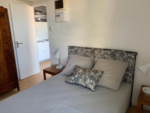 1 dormitorio con 1 cama con 2 almohadas en Bungalows Les Charmilles, en La Saline-Les-Bains